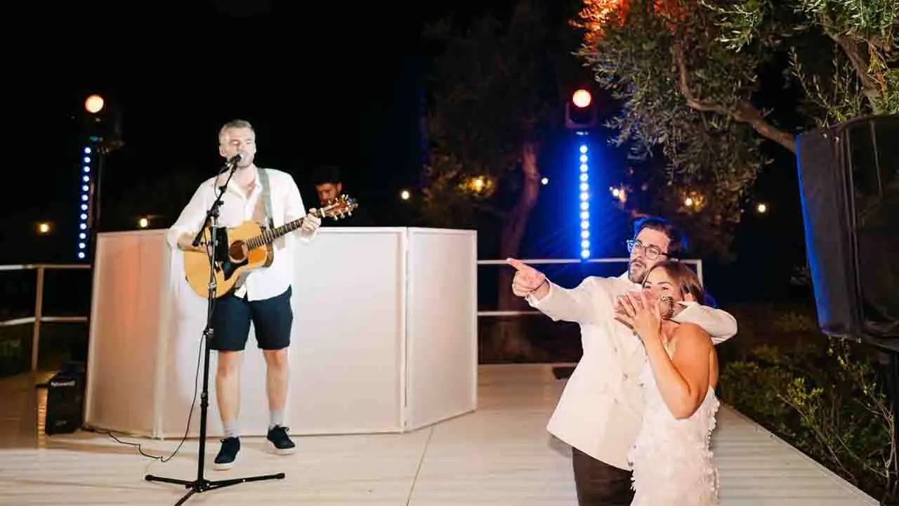 A lively wedding party in a Puglia Masseria with a live band performing under fairy lights at night